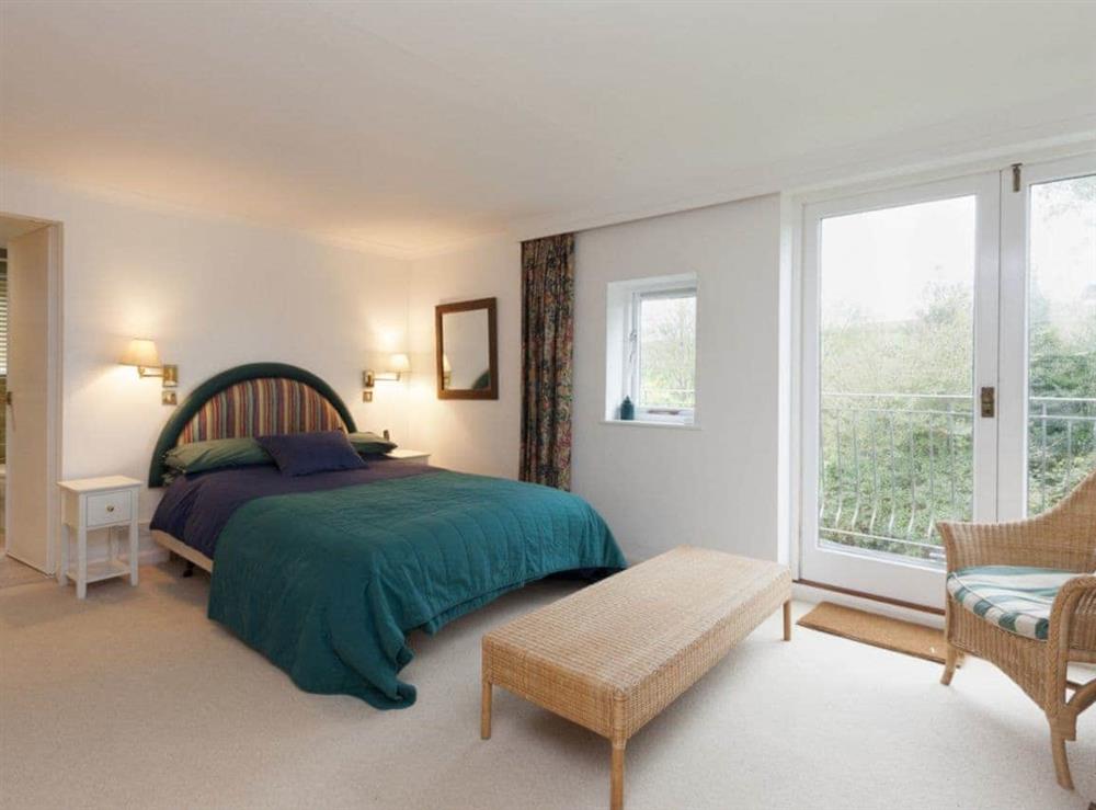 Double bedroom with ensuite bathroom and french doors to balcony at Spring Shaw in Higher Batson, Devon