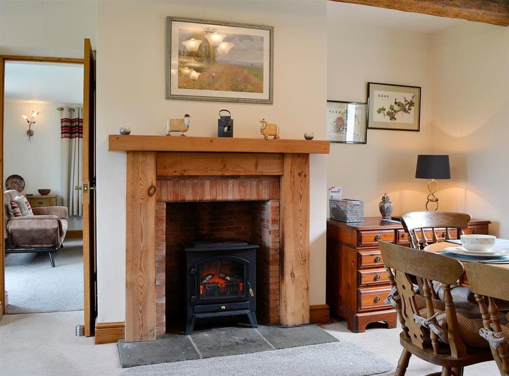 Dining area with feature fireplace at Farm Cottage, 