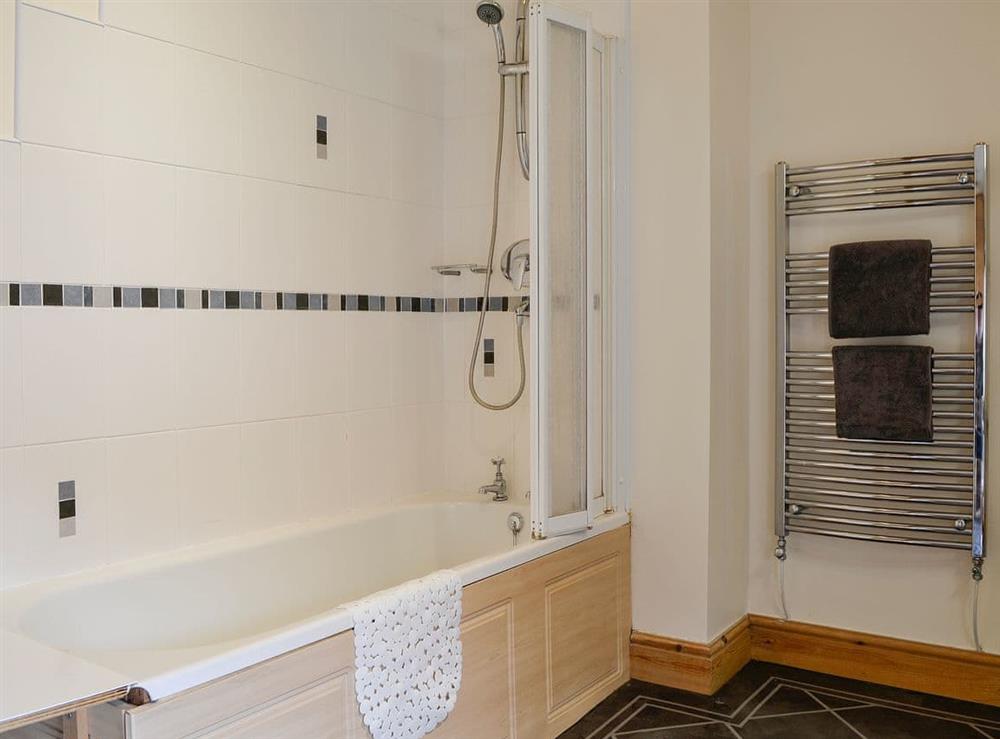 Tiled bathroom with shower over the bath at Farm Cottage, 