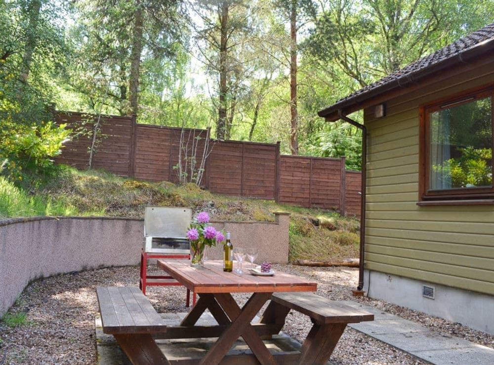 Private garden area with barbecue and picnic style seating at Squirrel Cottage in North Kessock, Inverness-Shire