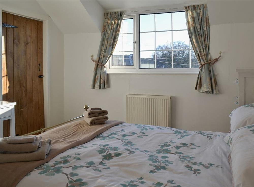 Pretty bedroom with antique-style bed at Squirrel Cottage in Seamer, near Scarborough, North Yorkshire