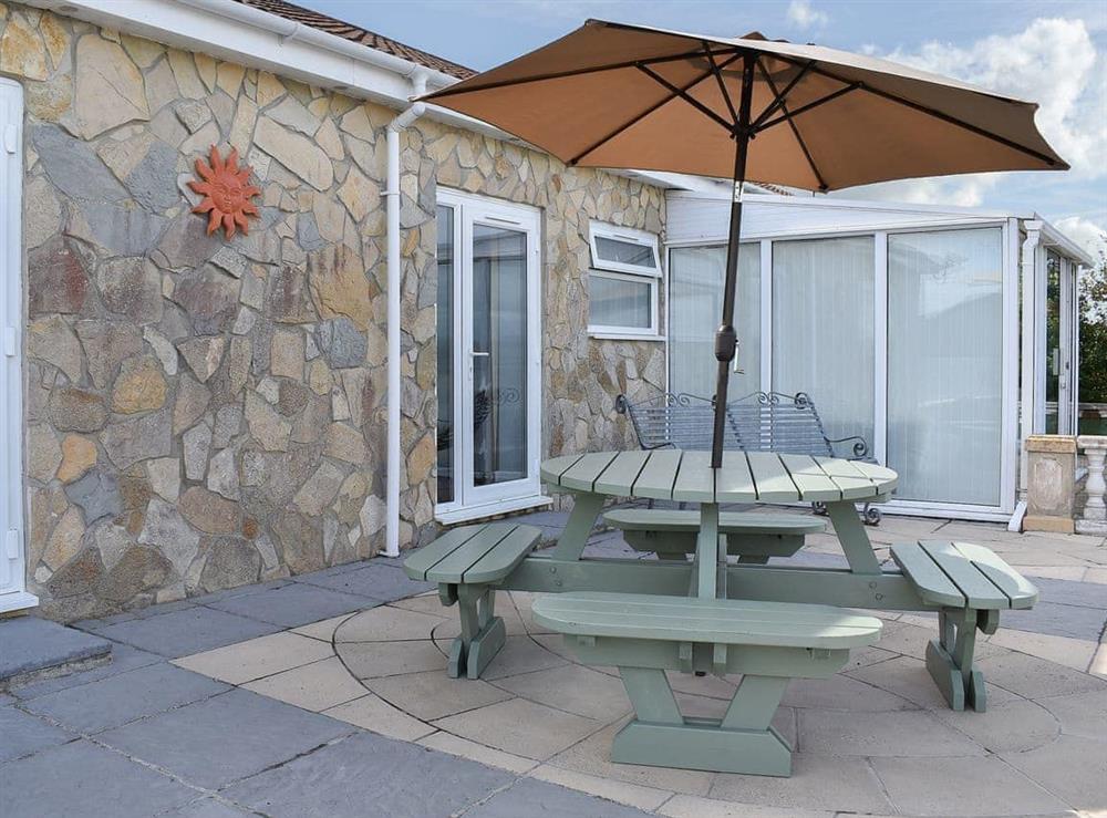 Sheltered spot on the patio for alfresco dining at Sunset Cottage, 