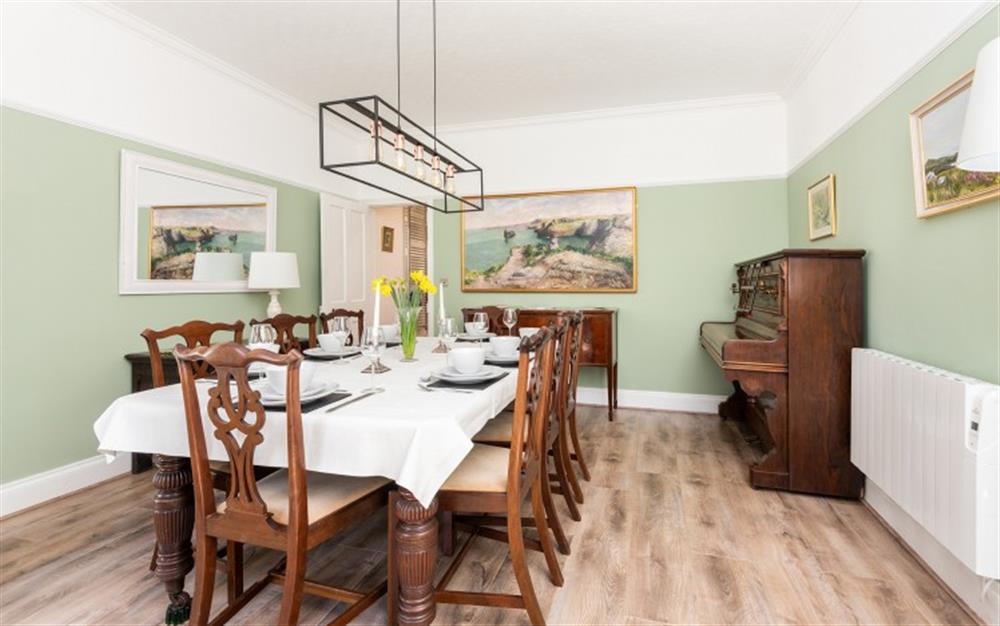 Spacious dining room with large dining table seating for 8, with upright piano at St. Brychan in Tintagel