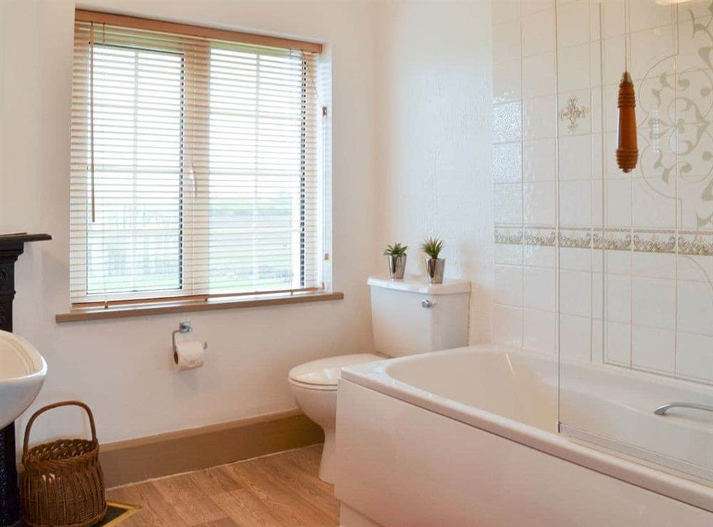 Bathroom with shower over the bath at St Cadoc Cottage in Harlyn Bay, near Padstow, Cornwall