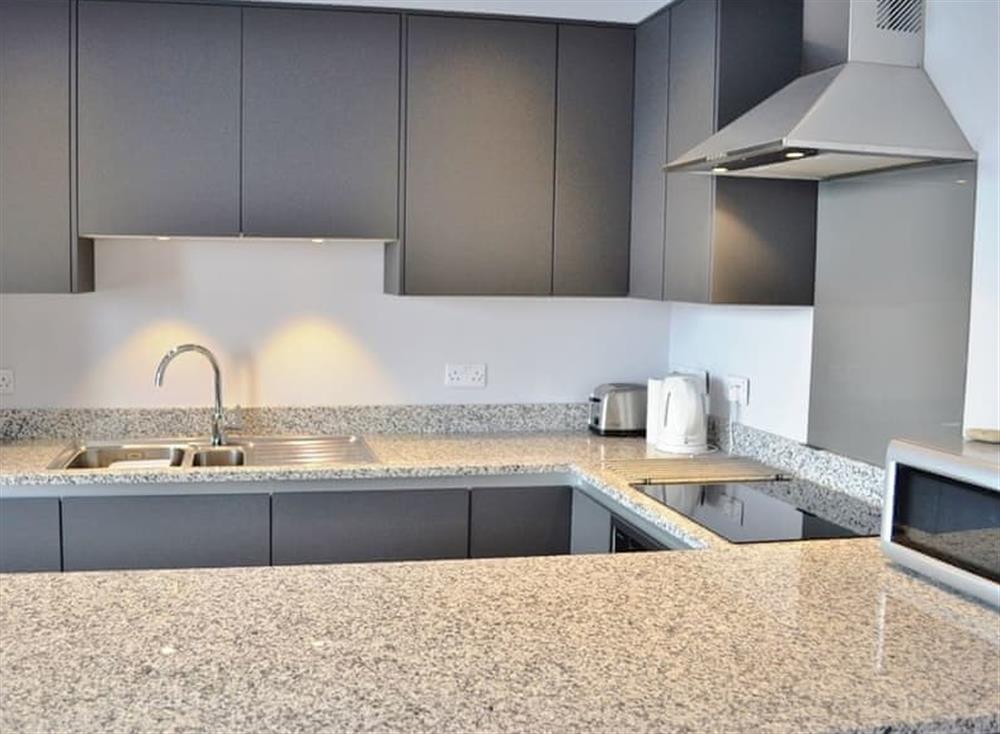 The modern kitchen has granite work surfaces at St Catherines Court No 4 in Fowey, Cornwall