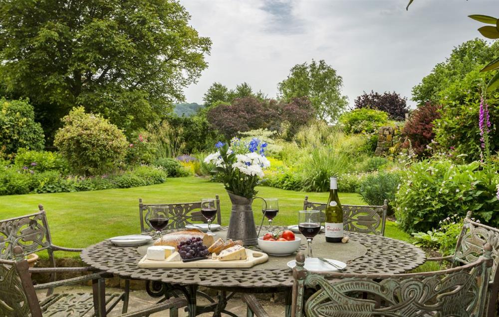 A terraced area accessed from the sitting room has a garden table and chars seating six at St Michaels Cottage, Broadway