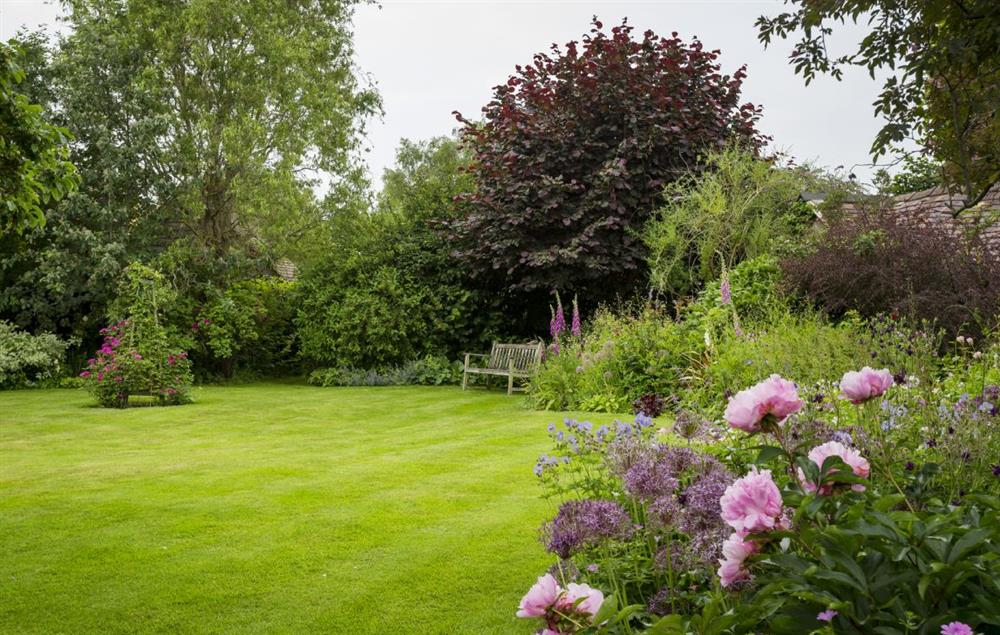 The lawned garden and well stocked borders feature many cottage garden favourites at St Michaels Cottage, Broadway