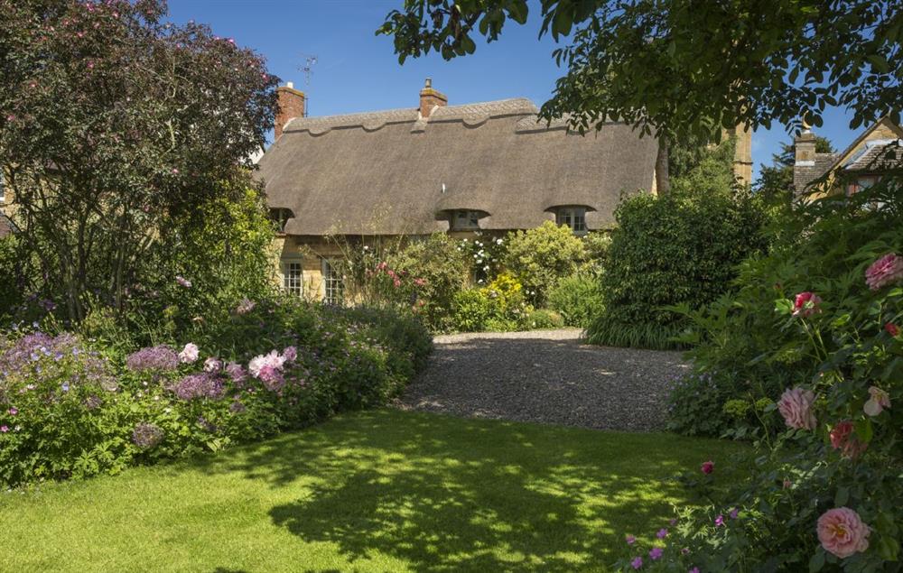 To the rear of the cottage are fully enclosed gardens, partially laid to lawn with borders packed with colour and variety