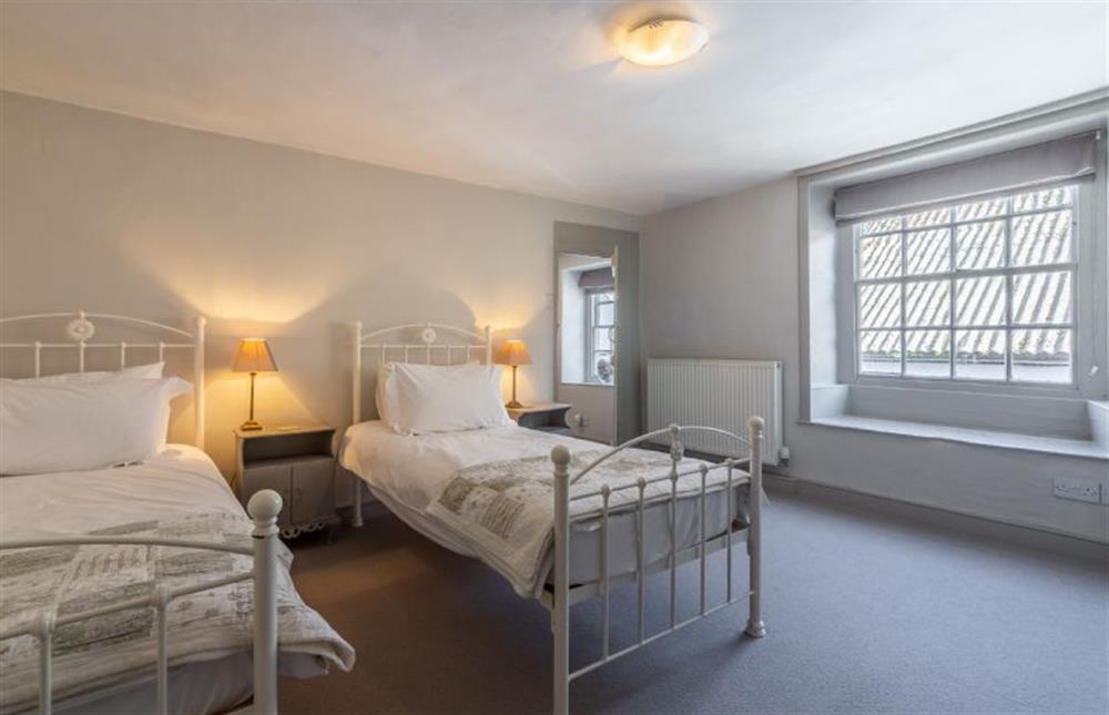 First floor: Bedroom two with two full-size single beds and views to front at St Michaels Cottage, Wells-next-the-Sea