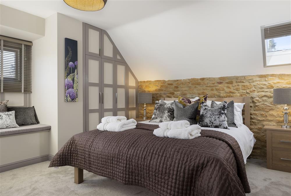 First floor: Bedroom one with a 5ft king size bed and en-suite bathroom at Stable Barn, Little Rissington