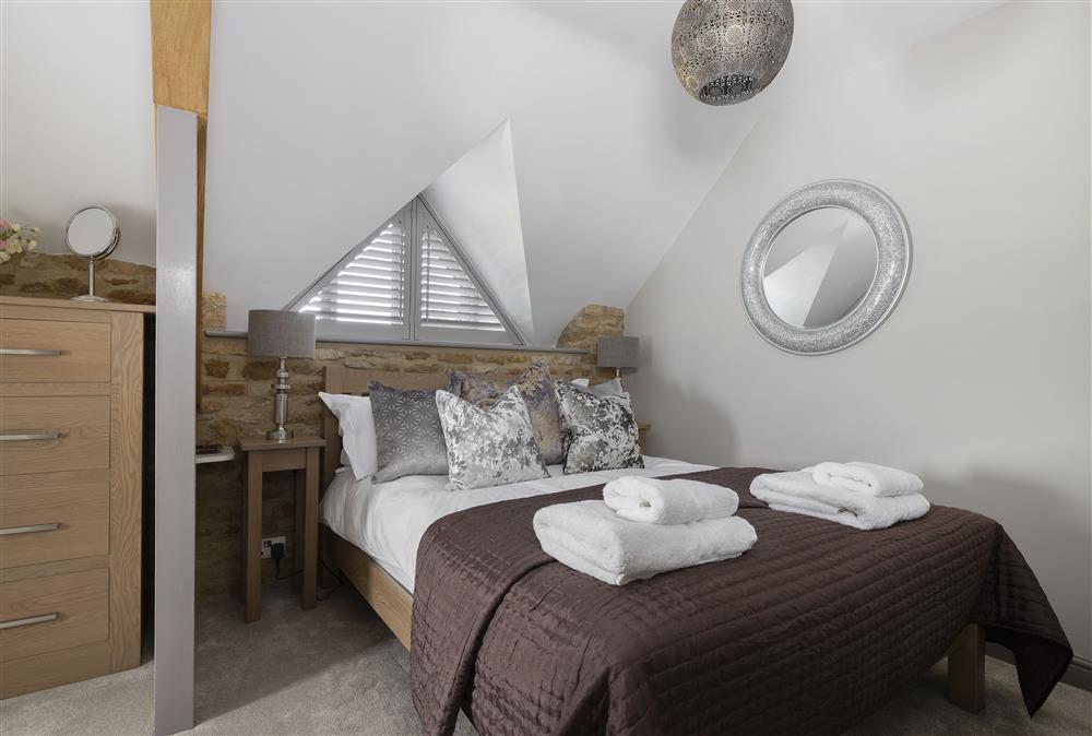 First floor: Bedroom two with double bed and en-suite shower room at Stable Barn, Little Rissington