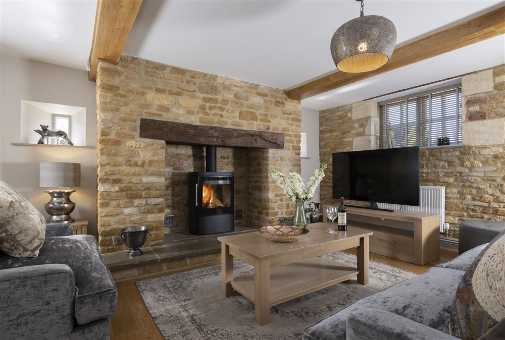 Ground floor: Cosy sitting room with wood burning stove and comfortable seating at Stable Barn, Little Rissington