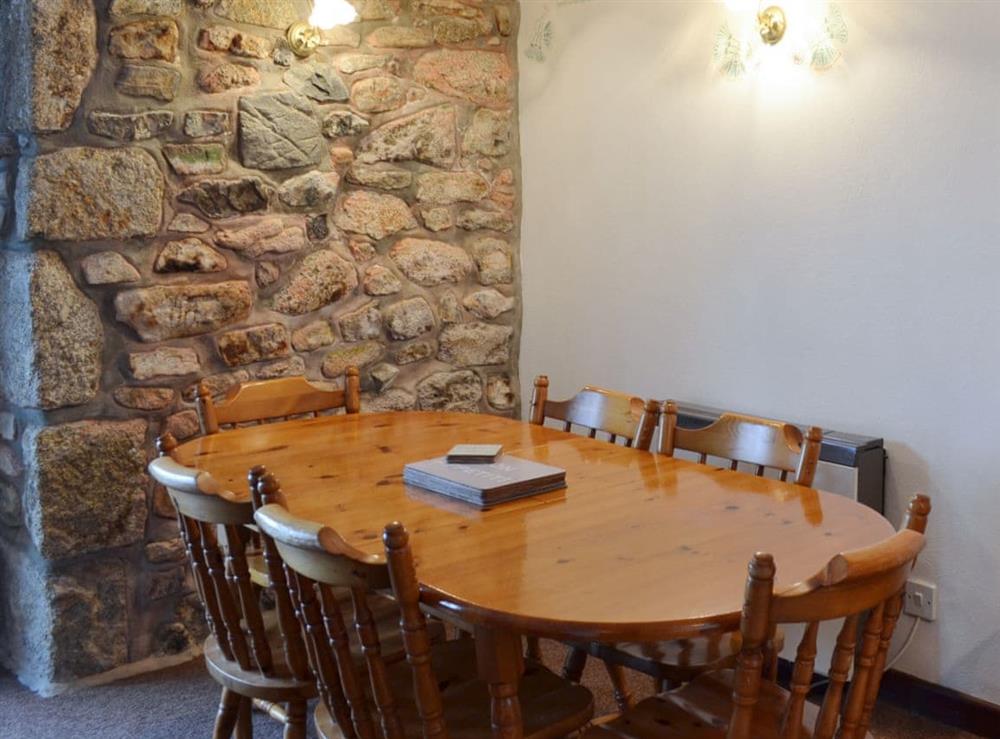 Dining area with exposed stone wall at Stable Cottage in Gulval, near Penzance, Cornwall
