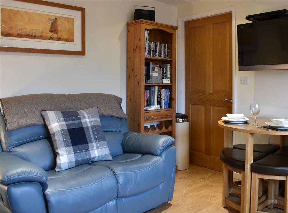Comfortable living area with modest dining table and chairs at Stable Cottage in Thirsk, North Yorkshire