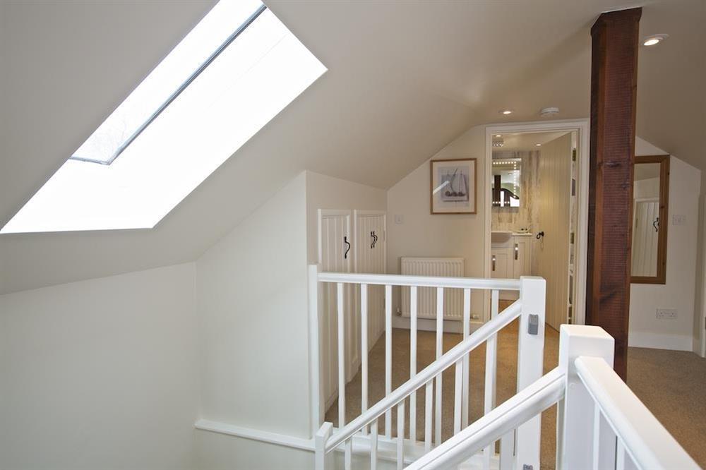 Stairs lead up to the first floor studio bedroom with 6'  bed and en suite bathroom at Stable End Cottage in Malborough, Nr Salcombe