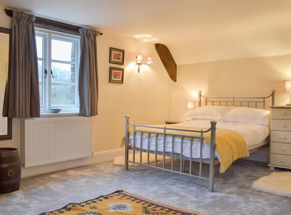 Delightful bedroom with antique style double bed at Stable End in Stickle Path, near Watchet, Somerset