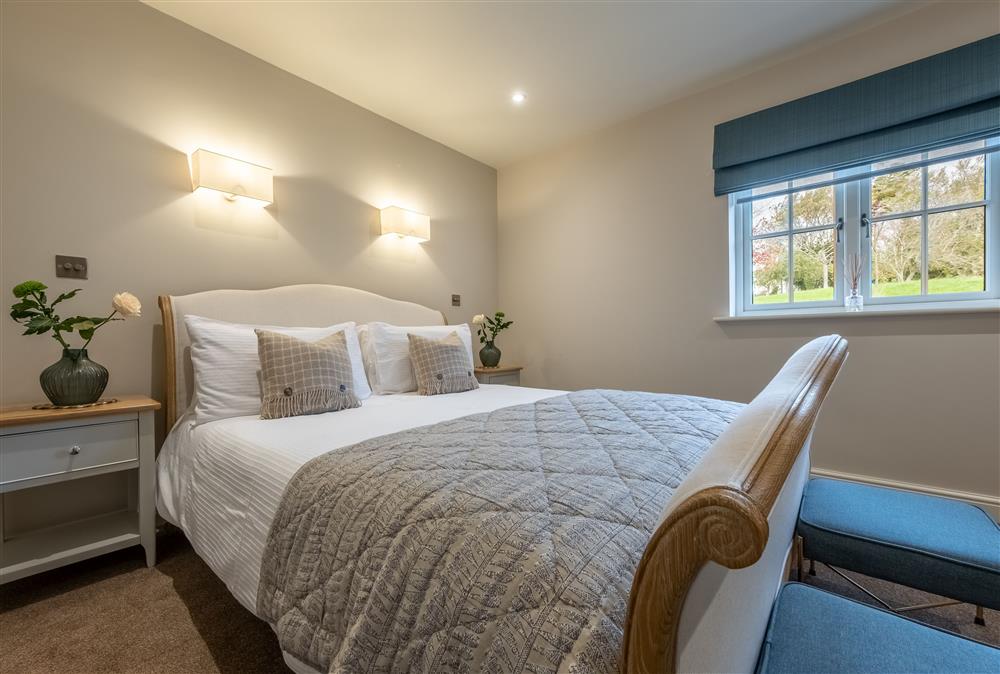 Bedroom one with its sumptuous 5’ king-size bed and en-suite bathroom at Stables Cottage, Tilton On The Hill