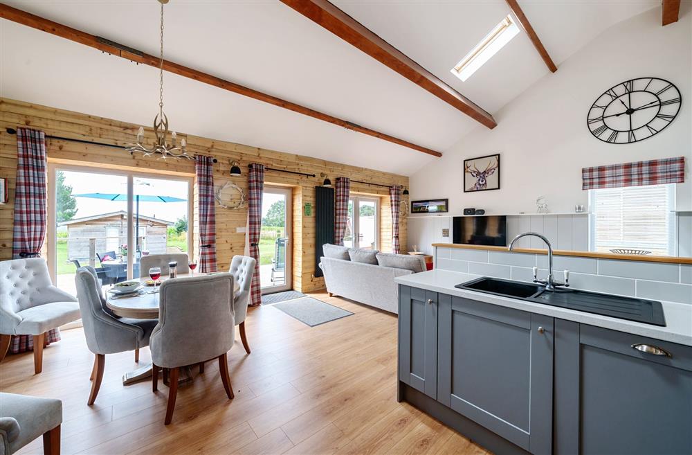 The open-plan kitchen, dining and sitting area with french doors leading to the sun deck at Stags Retreat, Sherborne