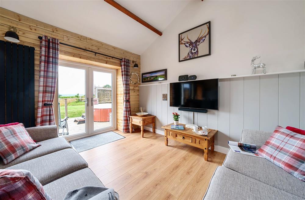 The sitting area with sofa bed available for children, and french doors leading to the sun deck at Stags Retreat, Sherborne