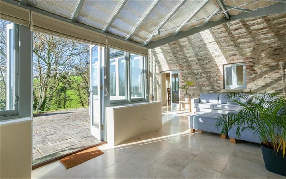 The sun room with doors on to the terrace. at Stancombe Cottage in Sherford