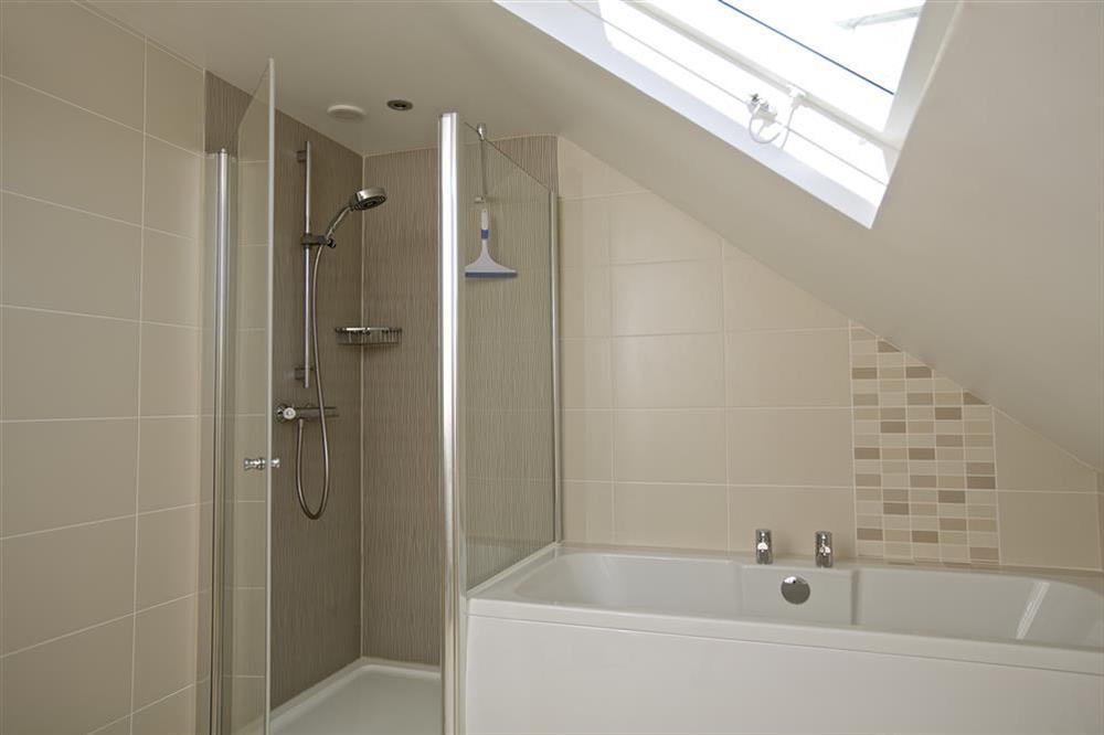 En suite bathroom with shower cubicle and bath at Starboard Light in Malborough, Salcombe