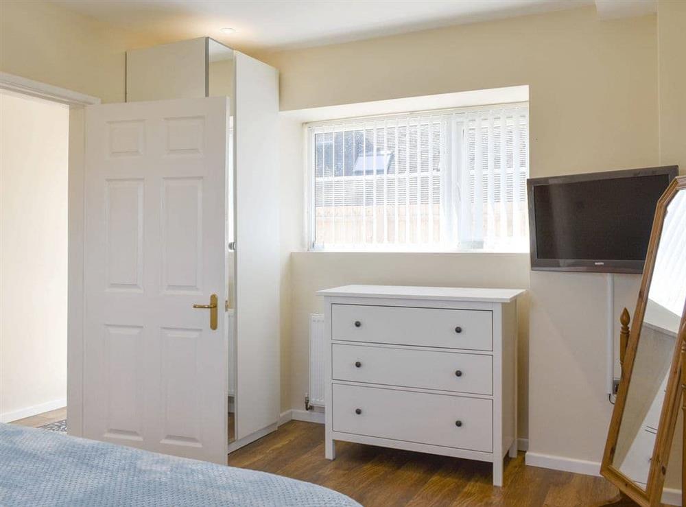 Ample storage and wall-mounted TV within double bedroom at Stars Cottage in Moreton, near Wareham, Dorset