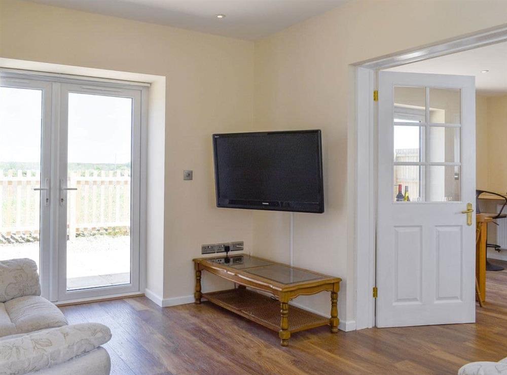 Spacious living area with French doors to patio area at Stars Cottage in Moreton, near Wareham, Dorset