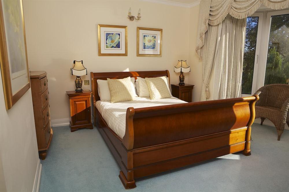 Master bedroom with sleigh bed and bay window to take in the superb view at Startline House in Newton Road, Salcombe