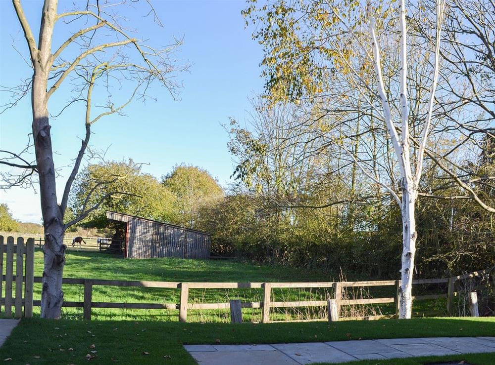 Lawned garden overlooking open fields at The Carriage House, 