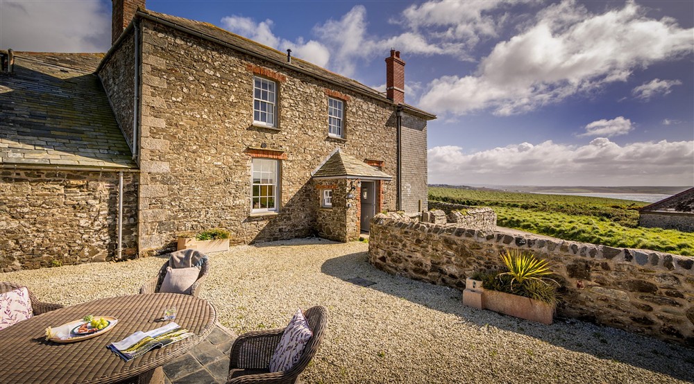 The front of Pengirt, with table and chairs on the gravelled terrace, Cornwall