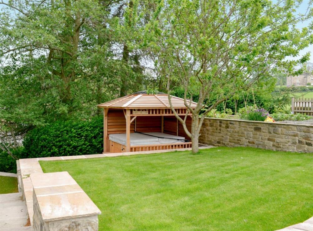 Attractive lawned garden and hot tub at Stirton Burrow in Stirton, near Skipton, North Yorkshire