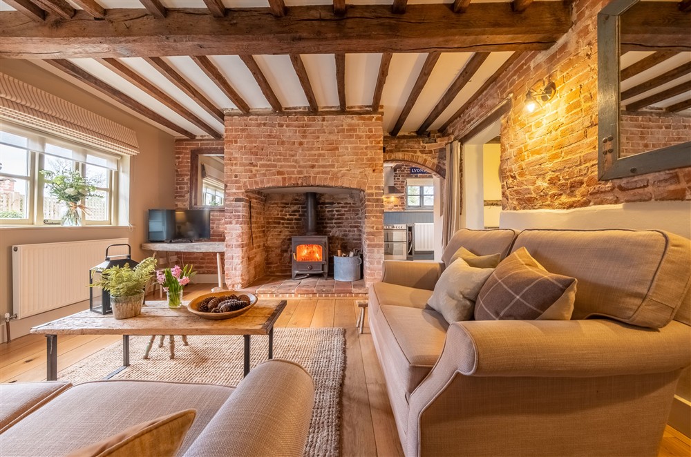 Cosy Sitting room with inglenook fireplace at Stockman's Cottage, Foulsham