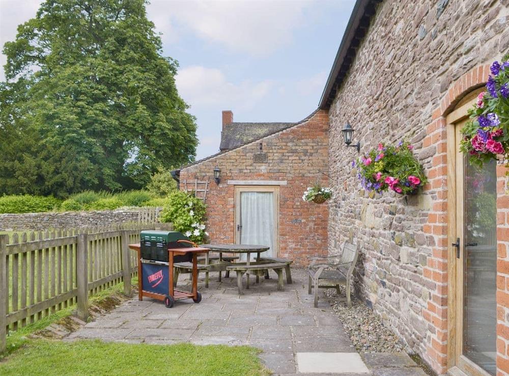 Paved patio area with BBQ to rear of cottage at Stoke Court Farm Barn in Stoke St Milborough, Nr Ludlow., Shropshire