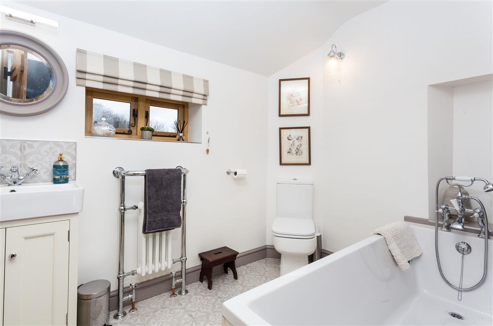 The family bathroom with a bath and hand-held shower at Stone House, Leominster