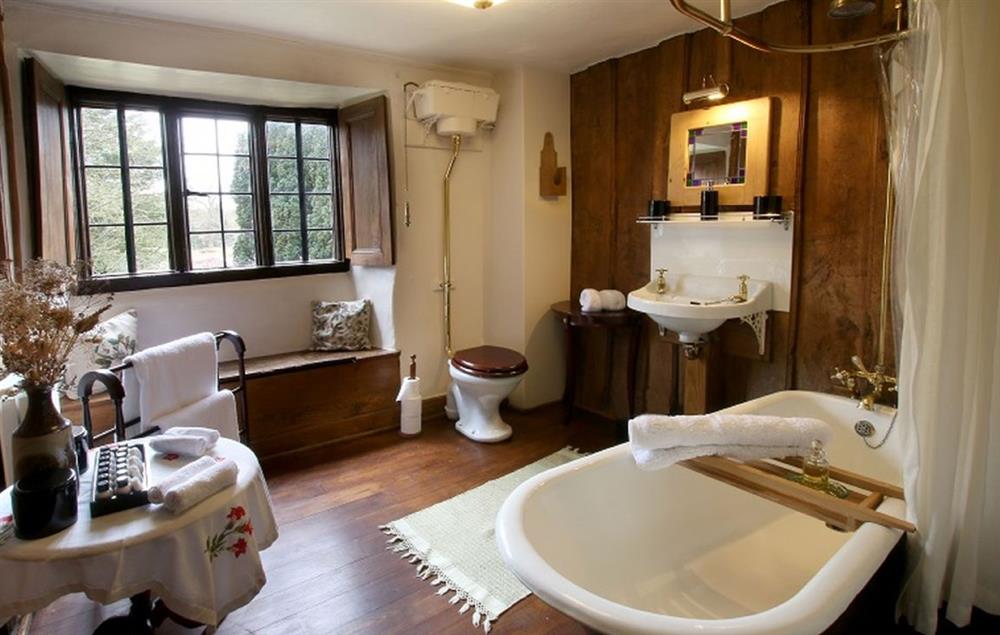 Adjacent bathroom with cast iron claw foot bath and overhead rain shower at Stourton Manor, Stourton