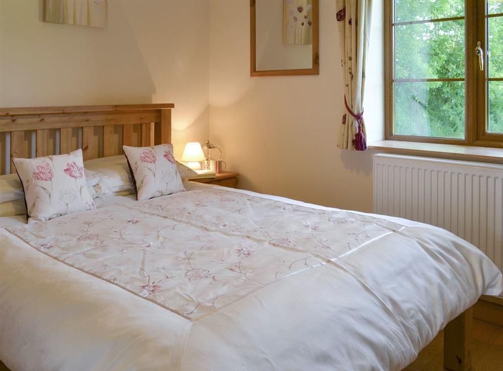 Relaxing double bedroom at Tarkas Holt Log Cabin, 