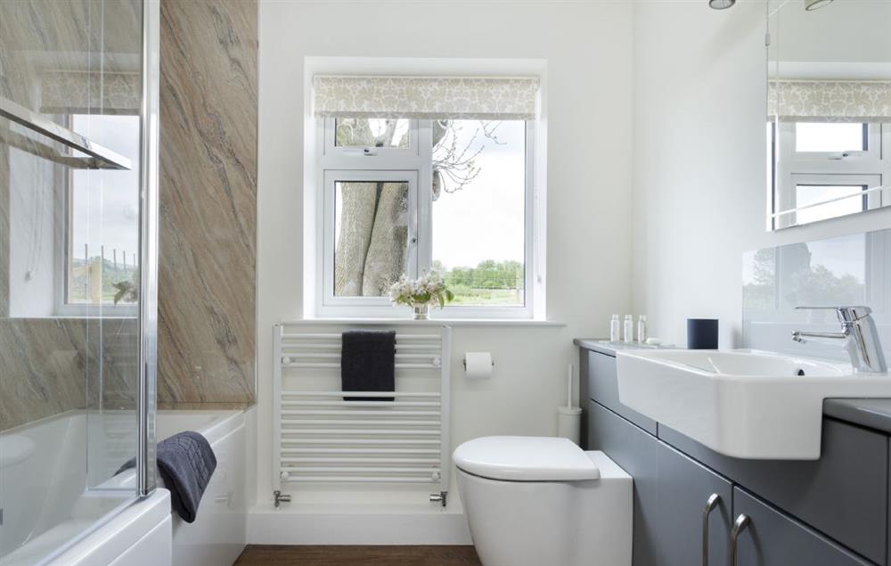 En-suite bathroom with bath and shower over at Strawberry Lodge, Billesdon