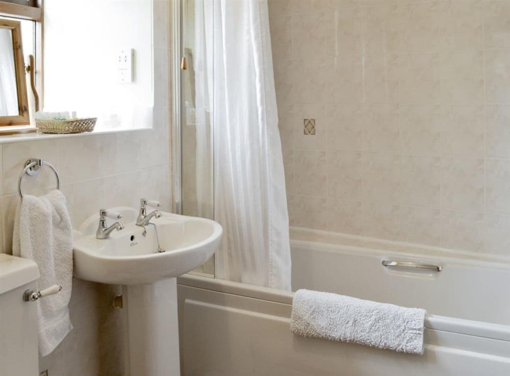 Family bathroom with shower over bath at Cow Pasture Cottage, 