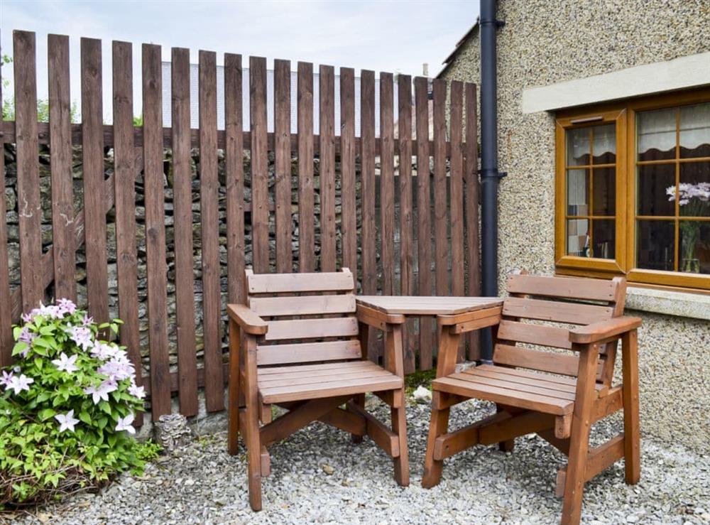 Small courtyard with sitting-out area and garden furniture at Swallowtail Cottage, 