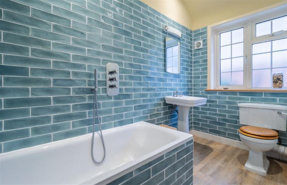 Family bathroom with bath with shower over, wash basin and WC at Suffolk House, Aldeburgh
