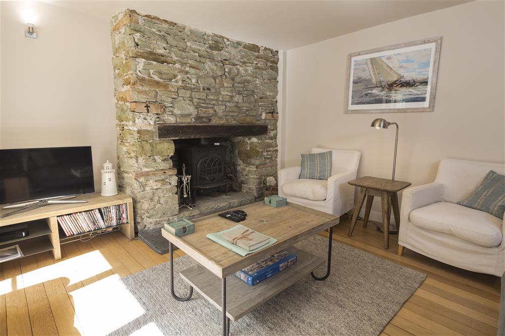A stone-faced Inglenook fireplace is a central feature of the sitting room at Summer Cottage in , Salcombe