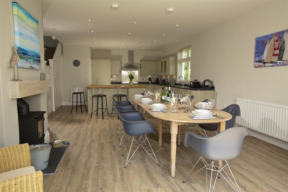 Dining area with wooden table and a small wood-burning stove at Sundowners in , Salcombe