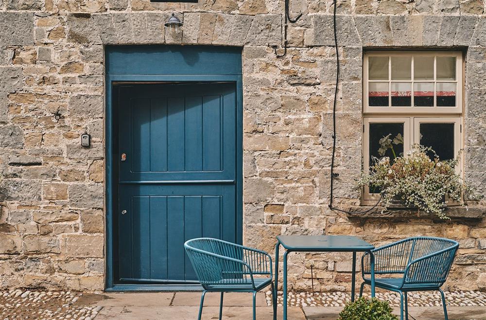 A table and two-chairs outside the entrance to Sunflower Cottage, Vale