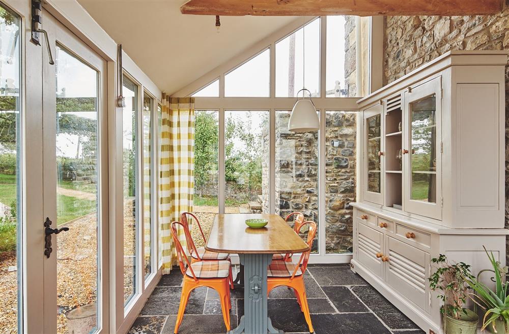 The conservatory with a dining table and four chairs