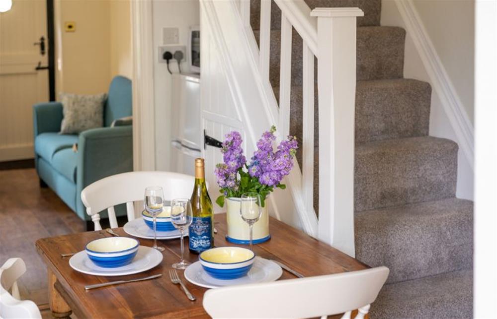Ground floor: Dining area with table for three guests at Sunny Beck Cottage, Mundesley near Norwich
