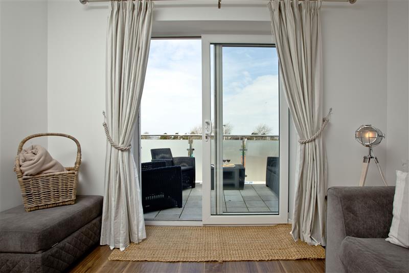 Living room with patio doors to the balcony at Sunnymead Penthouse, Exmouth, Devon