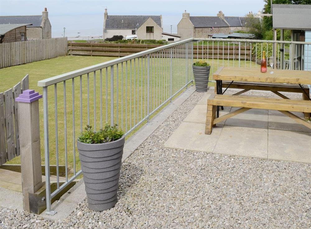 Paved patio area with outdoor furniture at Sunset Cottage in Portmahomack, near Tain, Ross-Shire