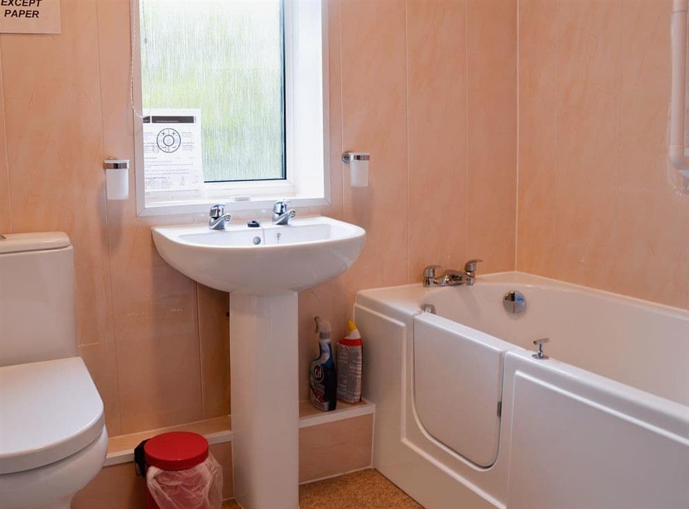 Bathroom with shower over bath at Sunshine Cottage in Fairford, near Cirencester, Gloucestershire