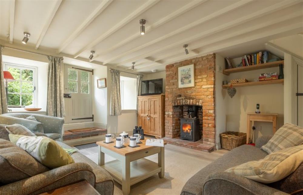 Cosy sitting room with wood burning stove at Sutton Cottage, Thornham near Hunstanton