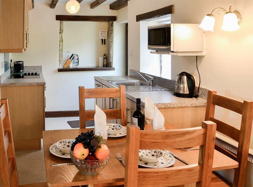 Dining area and adjacent kitchen at Swaledale Cottage in Caldbeck, near Keswick, Cumbria